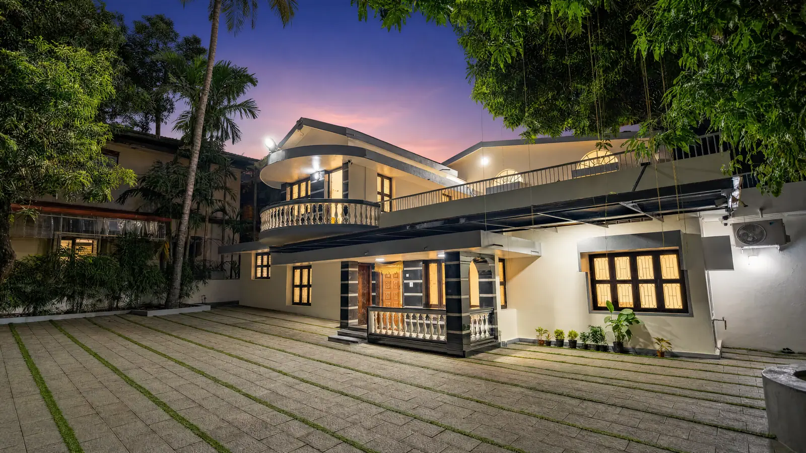 Spanda Homestay at twilight, the curved balcony glowing