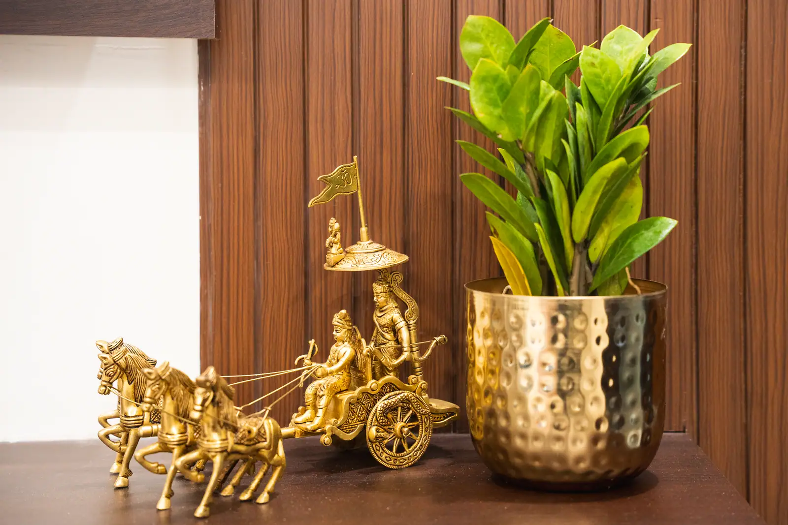 Intricate brass craftsmanship meets vibrant greenery, reflecting the timeless cultural heritage of our Udupi home.