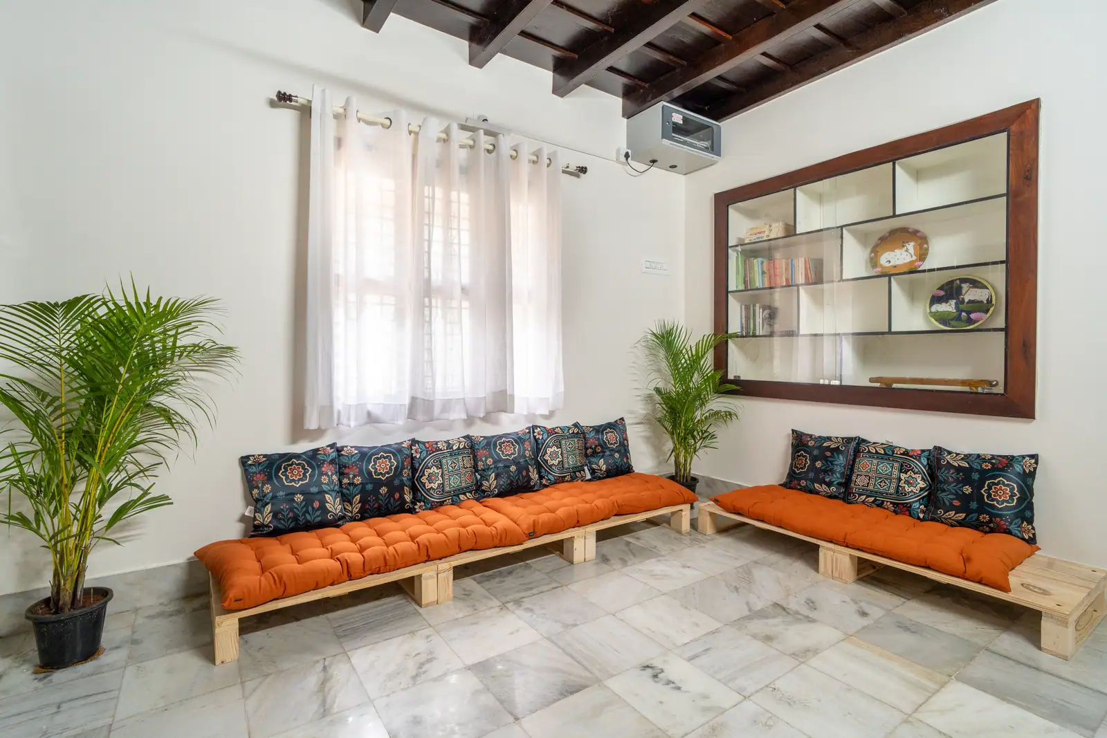The orange-cushioned floor seating in the living room