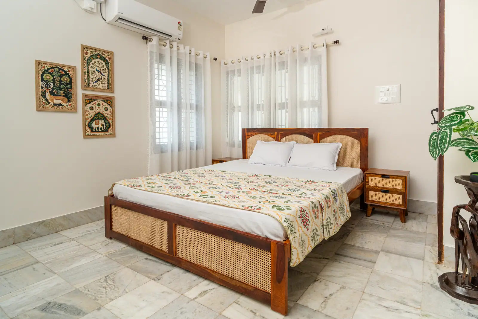 Natural light filters through sheer curtains, highlighting the warmth of handcrafted wooden furniture and traditional art.