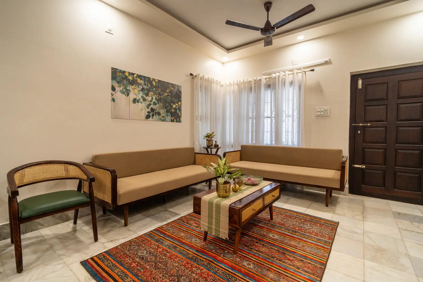 The sun-filled living room with cane furniture and kilim rugs