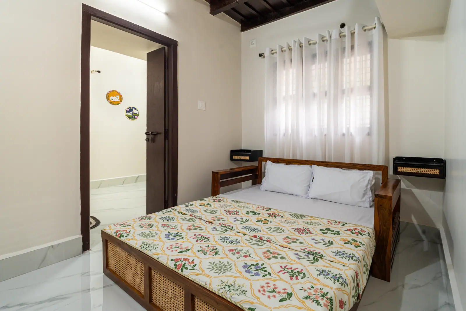 A serene bedroom featuring traditional wooden accents and soft, floral linens for a restful night.