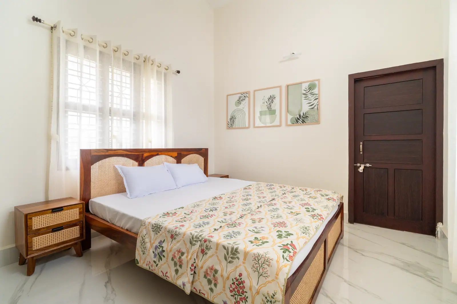 Natural light filters through sheer curtains, highlighting the warmth of cane-detailed furniture and botanical accents.