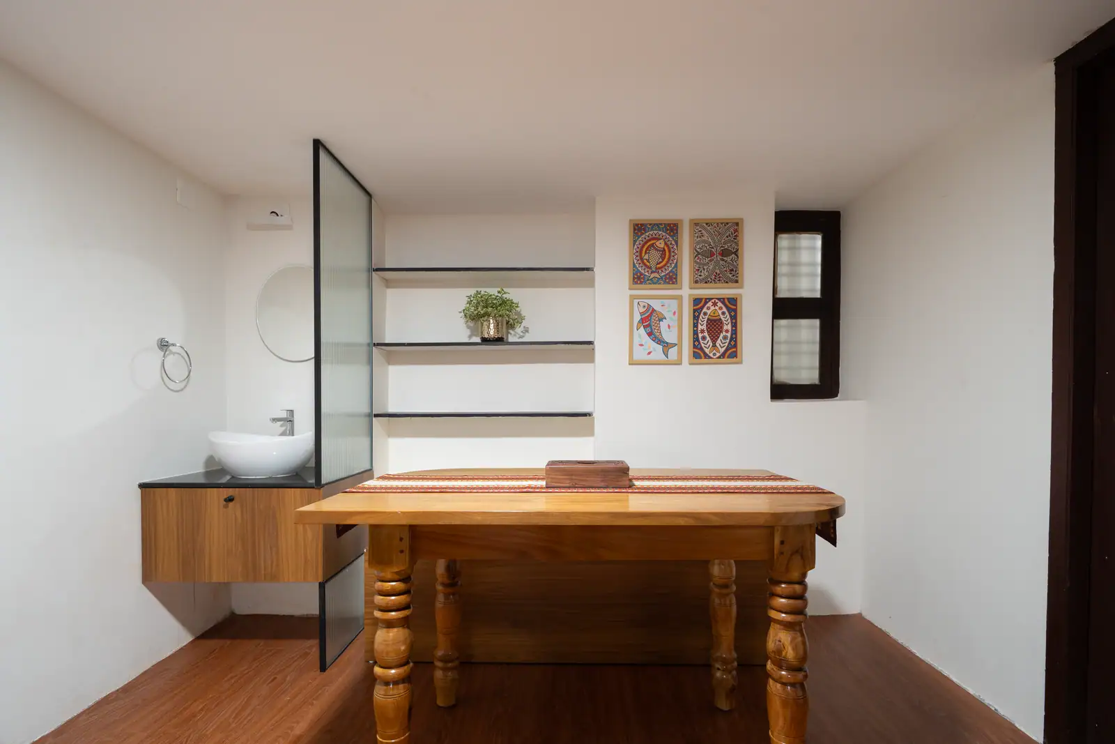A clean, minimalist vanity space featuring warm wood accents and traditional folk art touches.